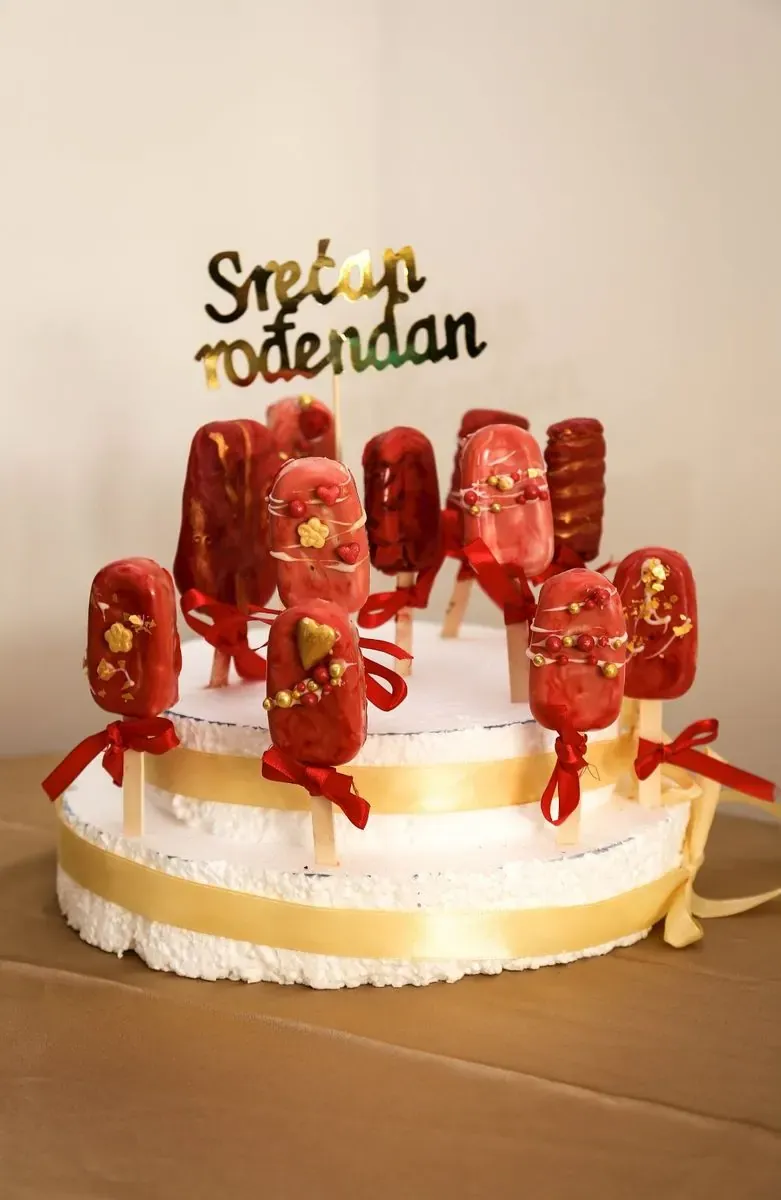 Crveni čokoladni pops sladoledi na postolju sa natpisom „Srećan rođendan“